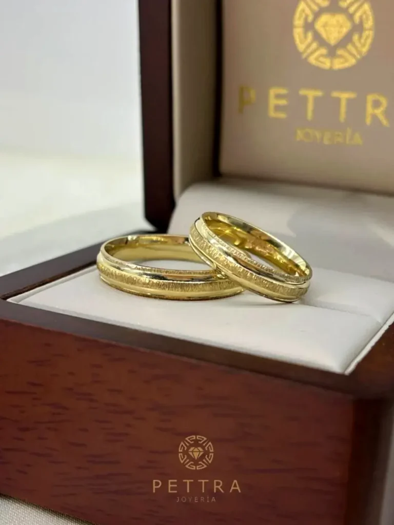 Anillo de oro en una caja de joyería elegante con el logotipo de Pettra.